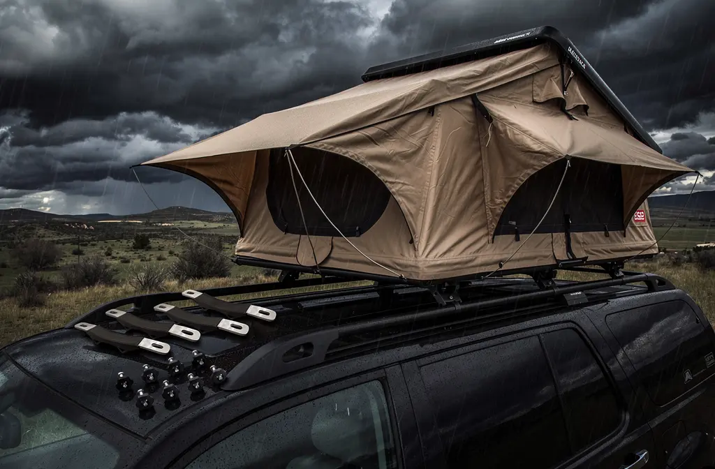 Kit de fixation tente de toit avec sangles et boulons installé sur un rack de voiture par vent fort