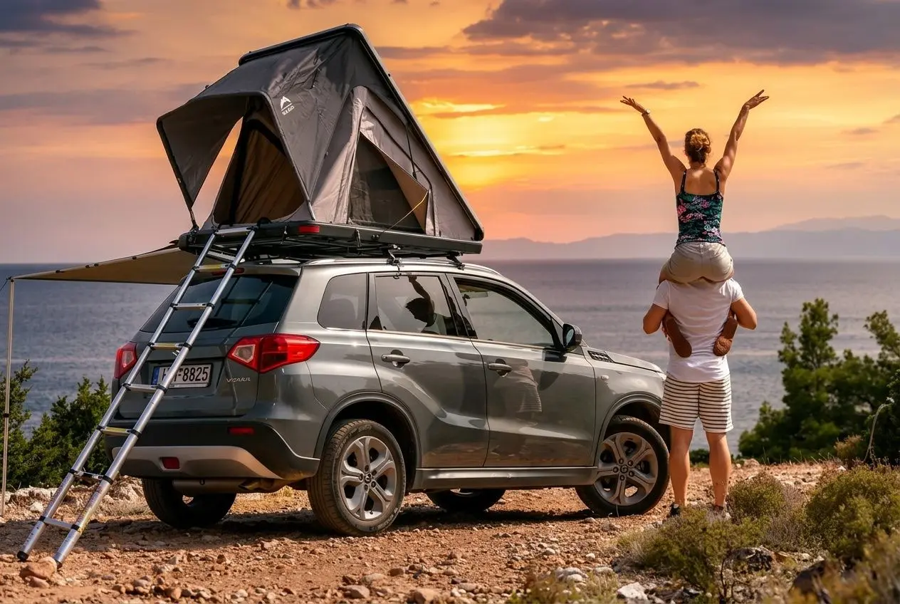 Tente de toit déployée sur un SUV garé en bord de mer au coucher du soleil.
